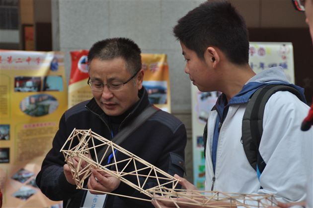 我校高二学生冯磊向省教科所技术组主任、特级教师李维明介绍自己的作品