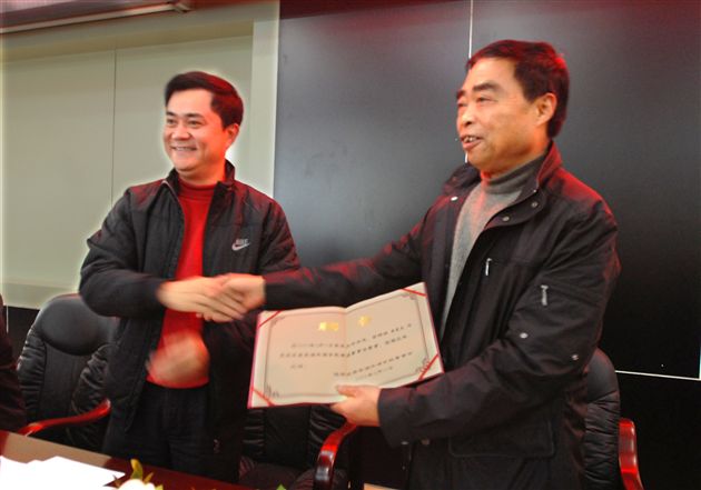 郭毅区长(左)为黄光成董事长(右)颁发聘书